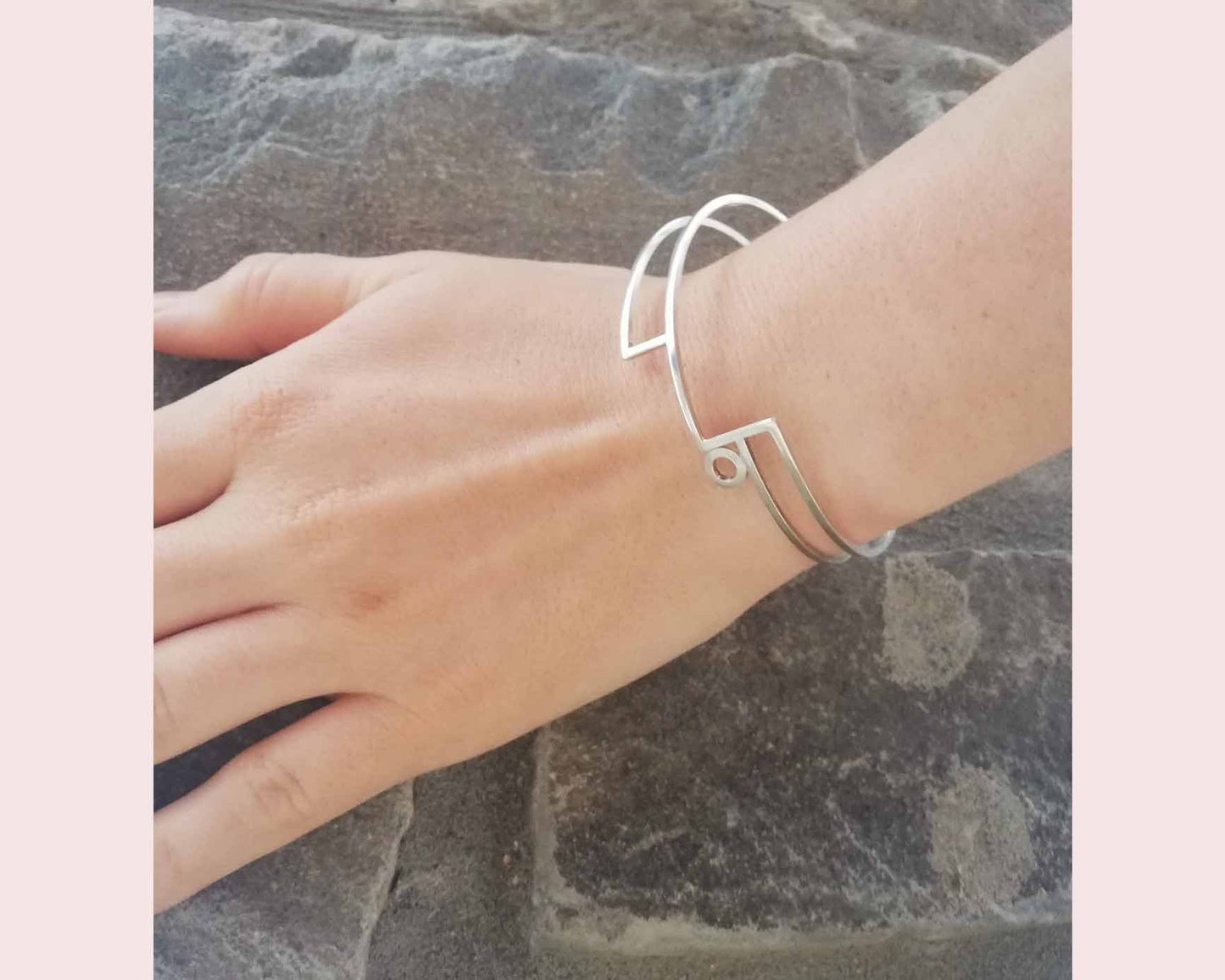 Silver linear stepped bangle with circle detail worn on wrist. Linear Bangle 2 part of Inplico Design and handmade by Roz Adams